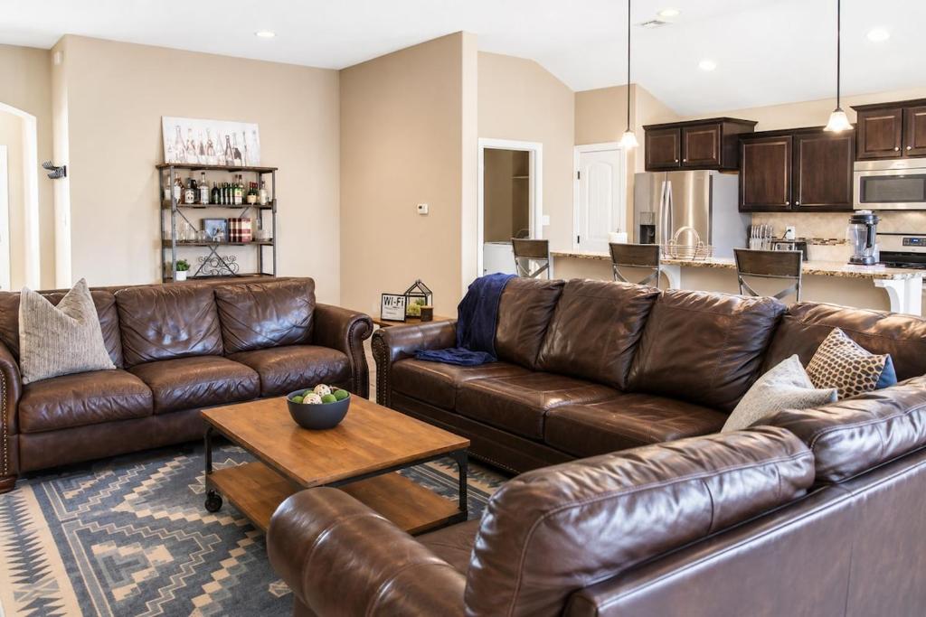 a living room with brown leather couches and a table at The Palo Pinto in Alamogordo