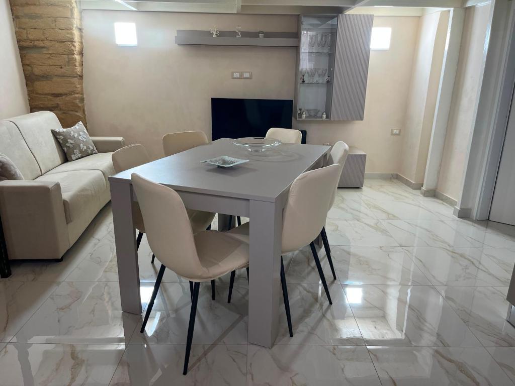a dining room with a white table and chairs at Imperial House in Poggio Imperiale