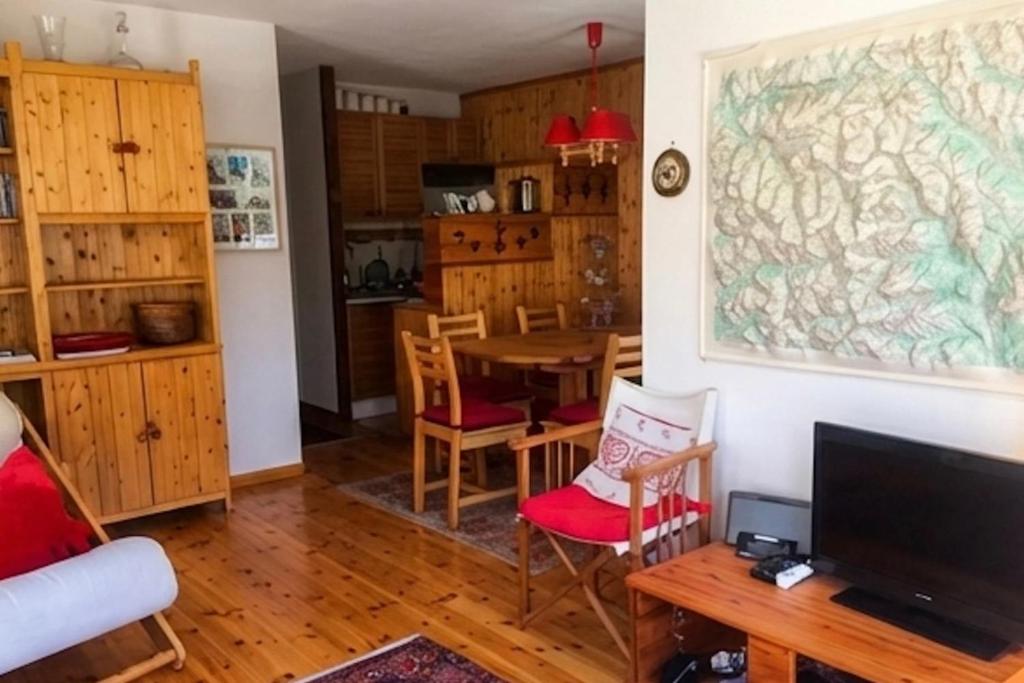 a living room with a table and a tv at Family mountain retreat with breathtaking views in Le Monêtier-les-Bains