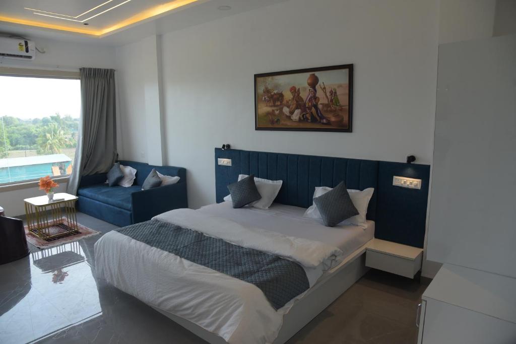 a bedroom with a large bed with a blue headboard at Hotel Ramayana in Ellora