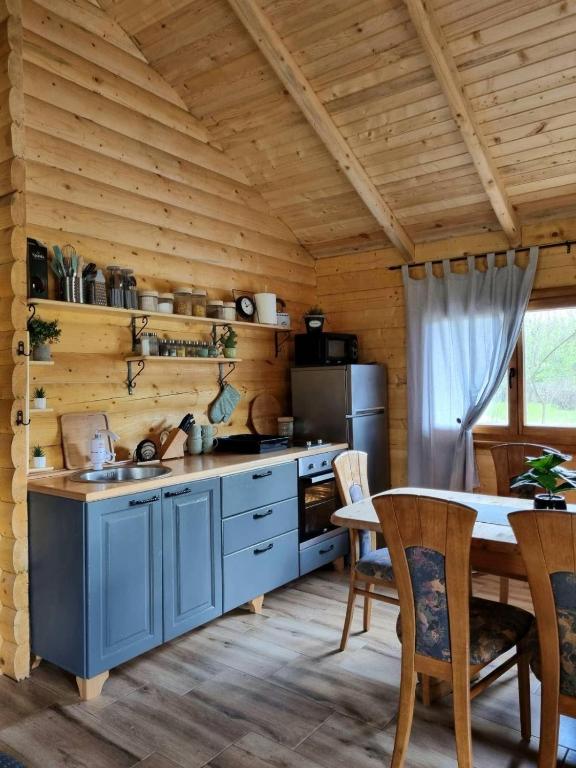 a kitchen with blue cabinets and a table with chairs at Brvnara Dina in Železnička Stanica Dolovo