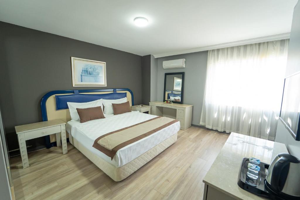 ein Schlafzimmer mit einem großen Bett mit blauem Kopfteil in der Unterkunft Sever Suites Hotel in Antalya