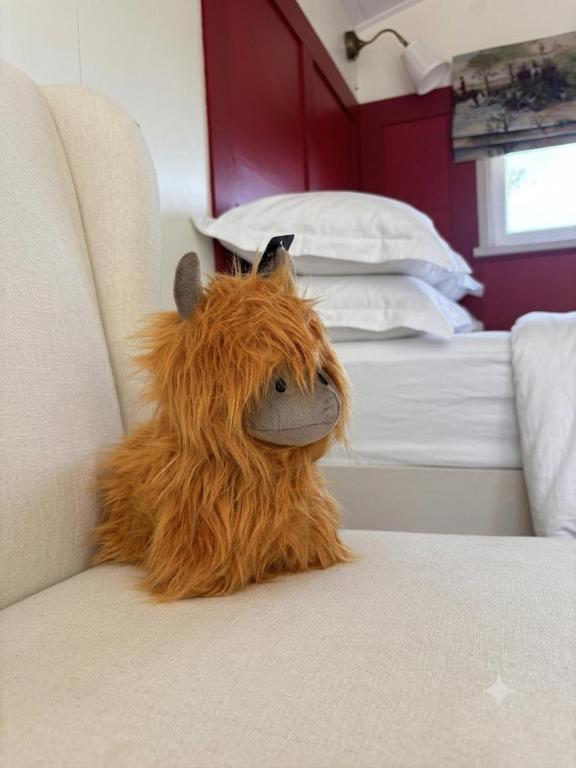 a stuffed animal is sitting on a bed at Blackthorn and Rose Shepherds Huts in Scribbagh
