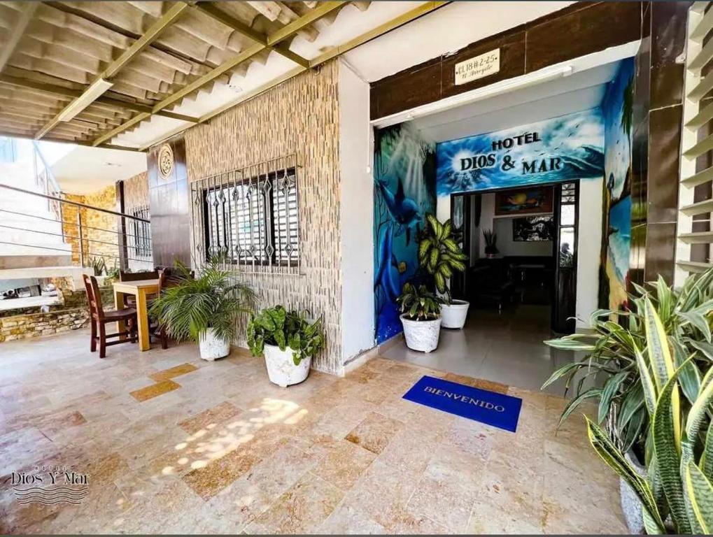 a lobby with plants and a sign on the wall at Hotel Habitaciones D y Mar in Tolú