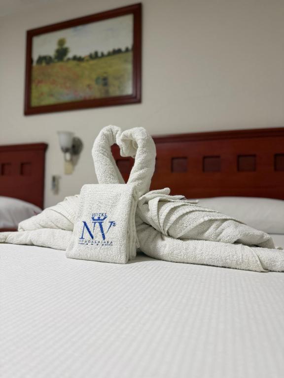 a pile of towels sitting on a bed at Hotel NV in Guadalajara