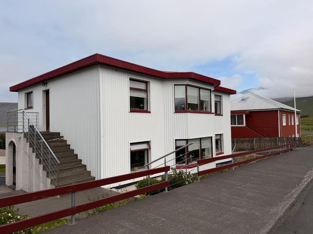 a white building with a red roof and stairs at G6 Apartment in Grundarfjordur