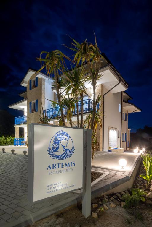 a sign in front of a building at night at Artemis Escape Suites Srebrno Jezero in Veliko Gradište