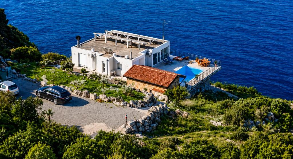 an aerial view of a house on the edge of the ocean at Private Sea View with Infinity Pool in VILLA NERIN Zagora in Zagora