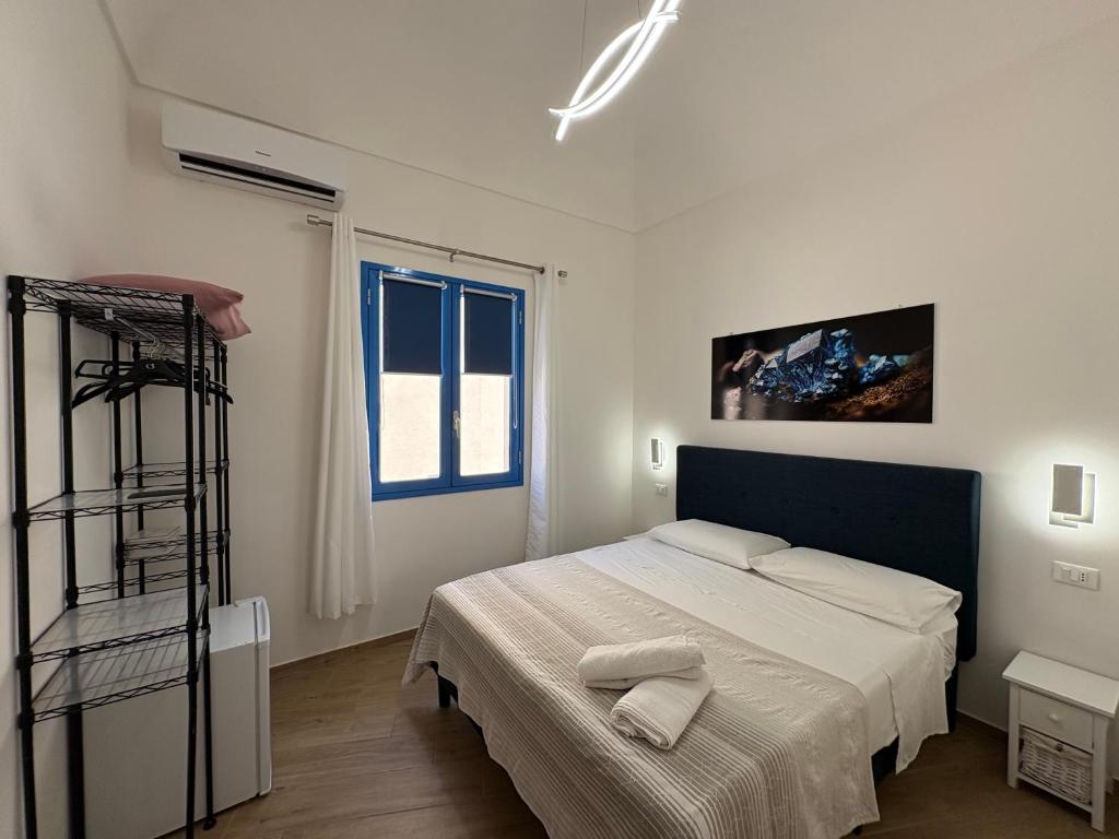 a white bedroom with a bed and a ladder at Struttura Le Gemme in Marettimo