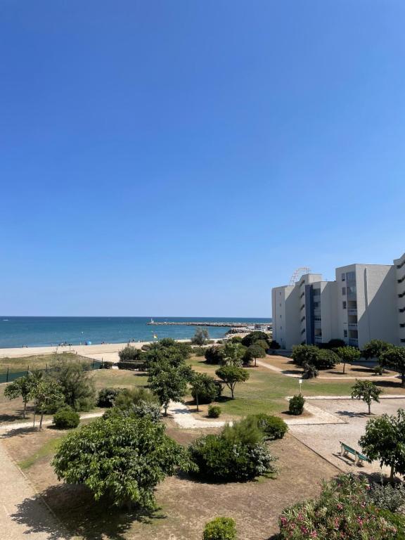 a view of the beach and buildings and trees at Residence Port Saint Ange in Le Barcarès