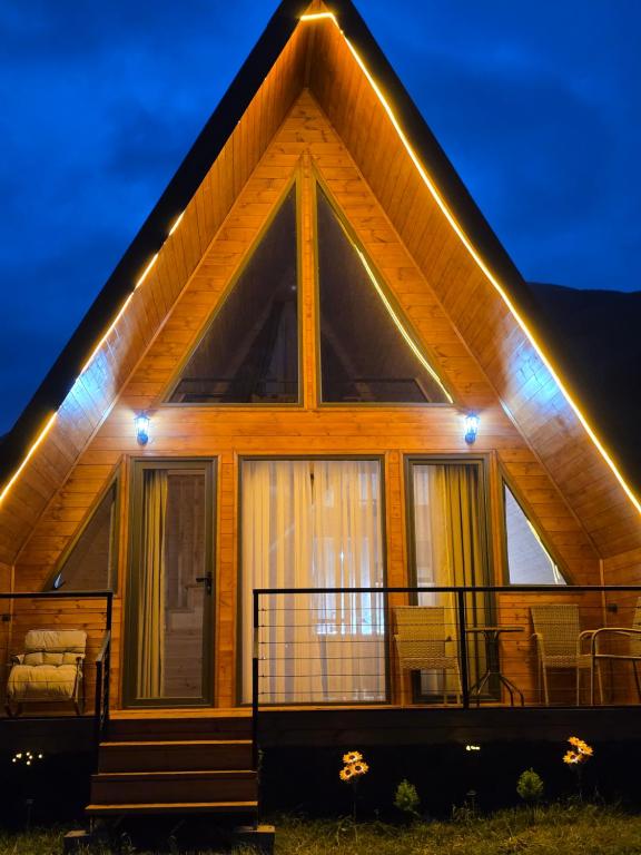 a house with lights on the front of it at Cottage MTIS DZIRSHI in Ach'khoti
