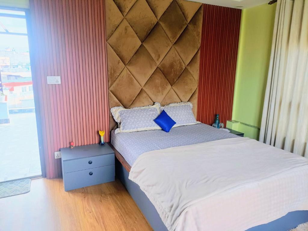 a bedroom with a large bed with a large headboard at Le Petit Paradis Nepal Terrace & Mountain View in Pātan