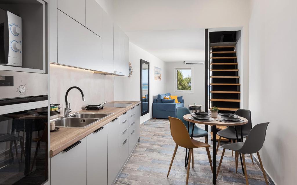 a kitchen with a table and chairs and a dining room at Limen Port View Studio in Tinos