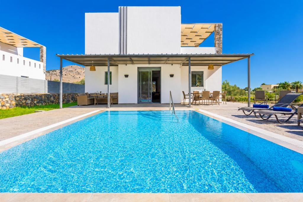 a villa with a swimming pool and a house at Villa Livis 1 in Kiotari