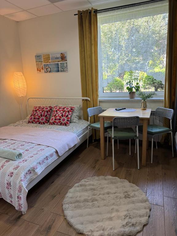 a bedroom with a bed and a table and a window at Pokoje Tanie Spanie in Zator