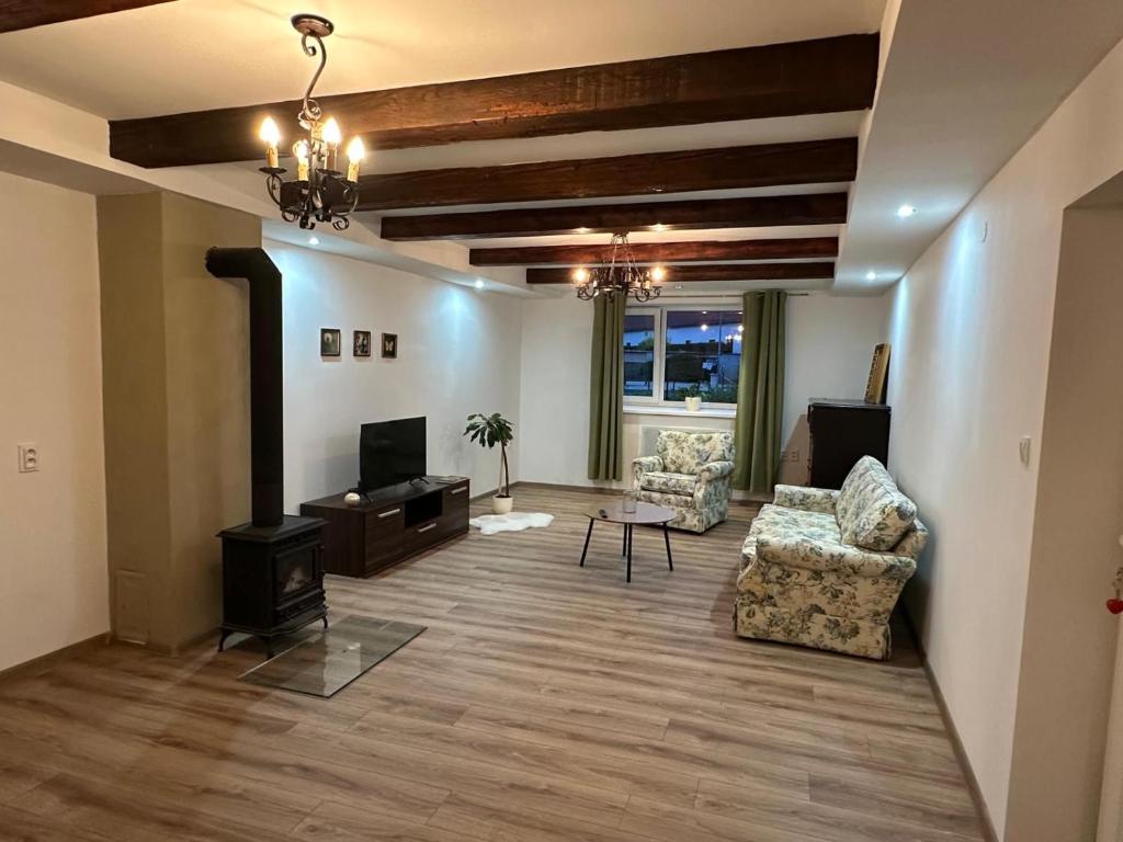 a living room with two chairs and a television at Chata pod hradom in Divín