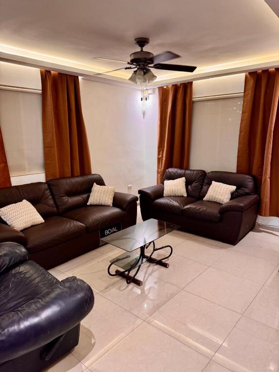 a living room with two couches and a ceiling fan at Victory House Mty in Monterrey