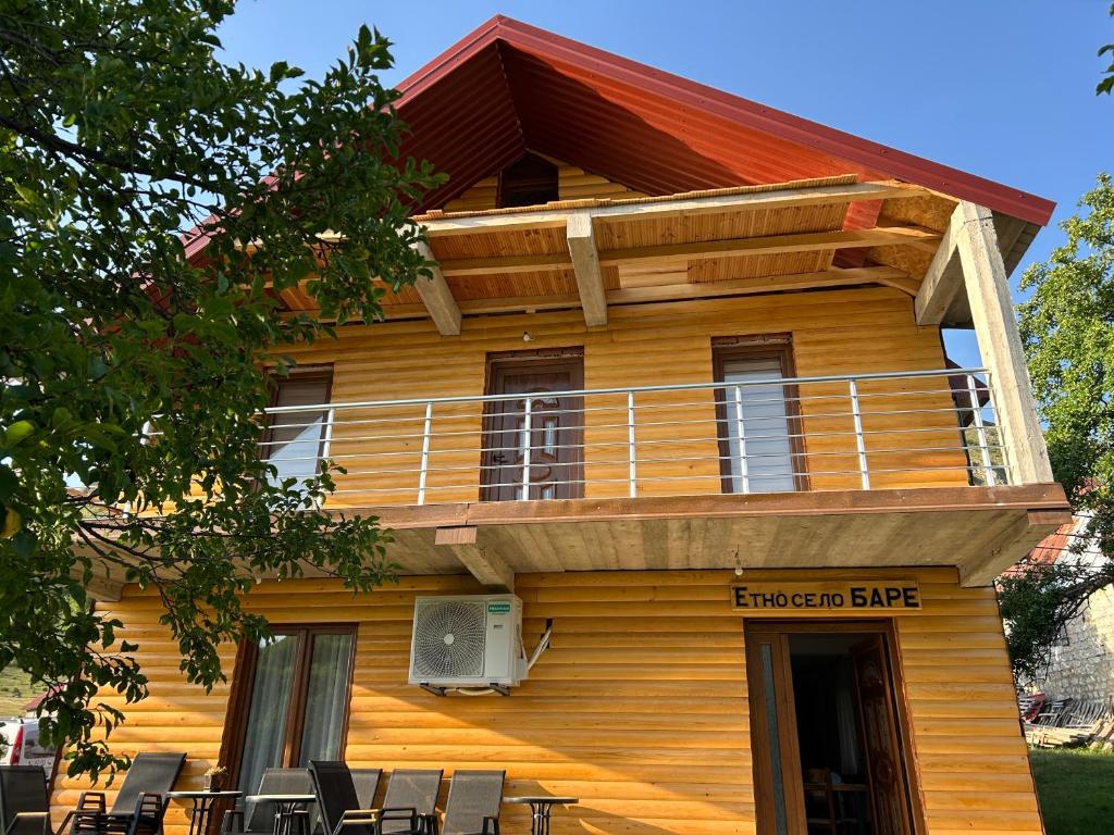 a building with a balcony on the side of it at Etno village Bare in Bare