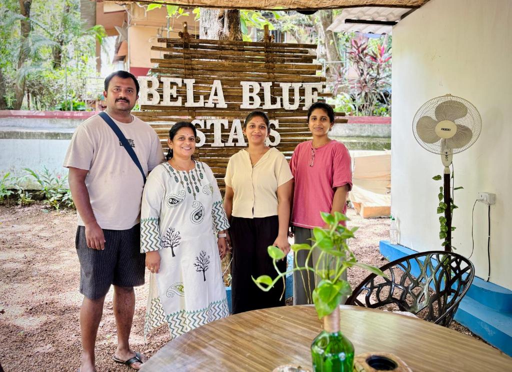 a group of people standing in front of a table at Bela Blue Stays in Bardez
