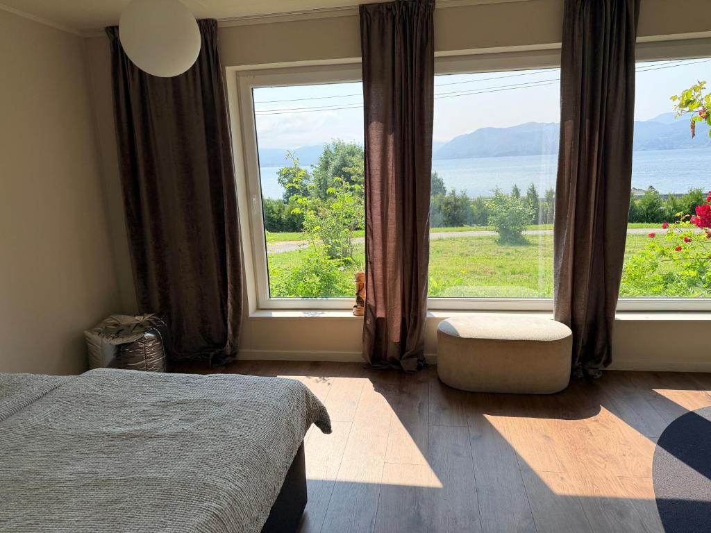 a bedroom with a bed and a large window at Panoramic Room with Sea View in Hundsnes