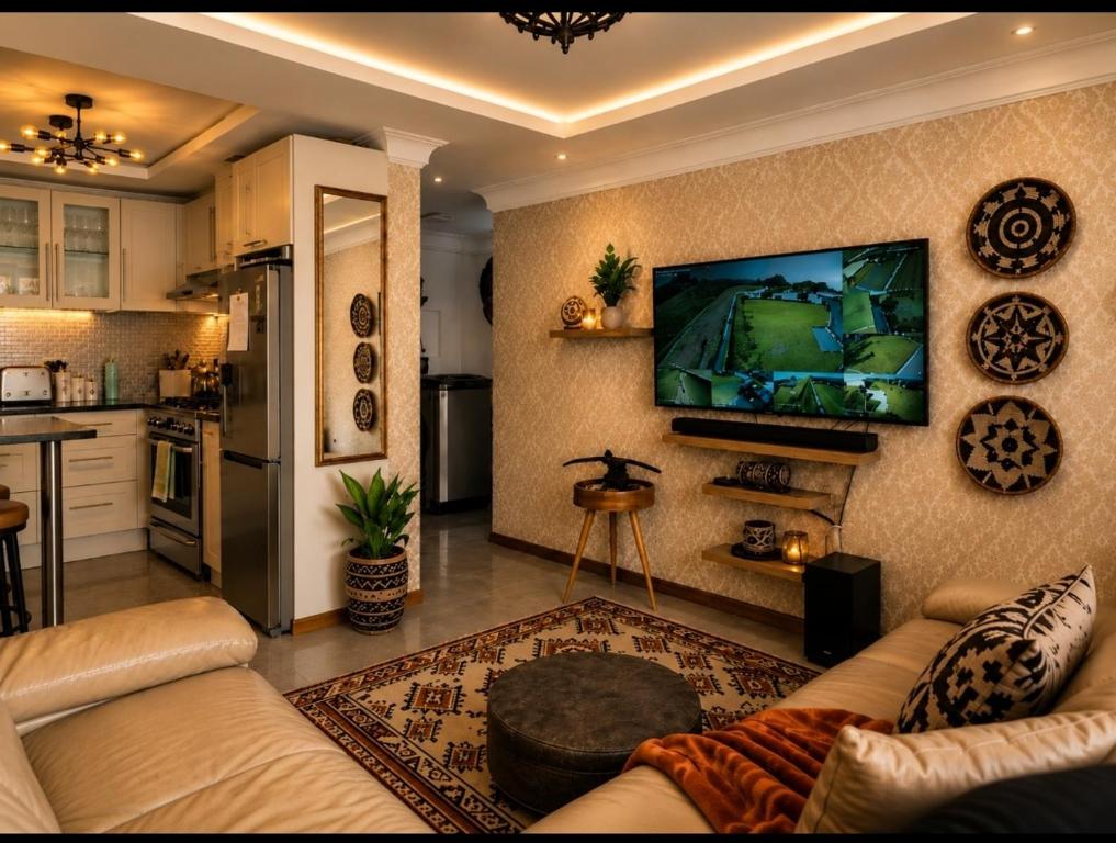 a living room with a couch and a tv on the wall at Eluthando Guesthouse in St Lucia