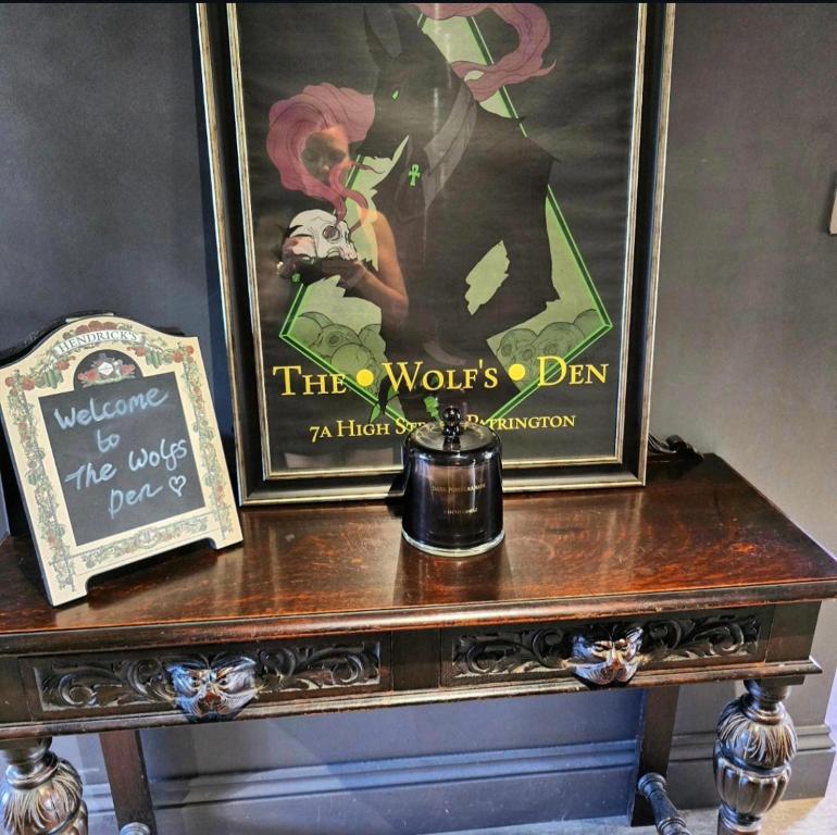 a table with two framed pictures on top of it at The Wolf's Den in Patrington