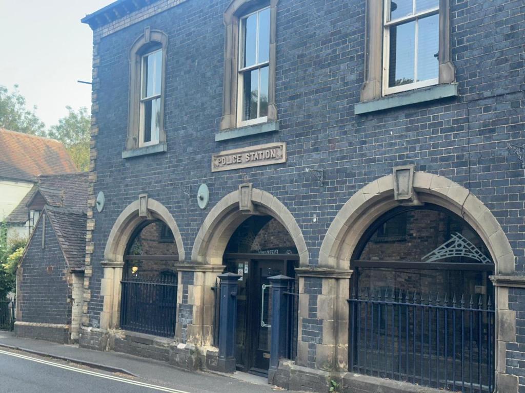 a brick building with two arches on the side of it at The Ironbridge Lockup - Former Cell in Ironbridge