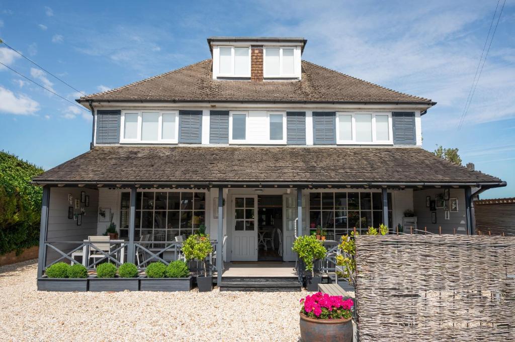 a blue house with flowers in front of it at The Beach House in West Wittering