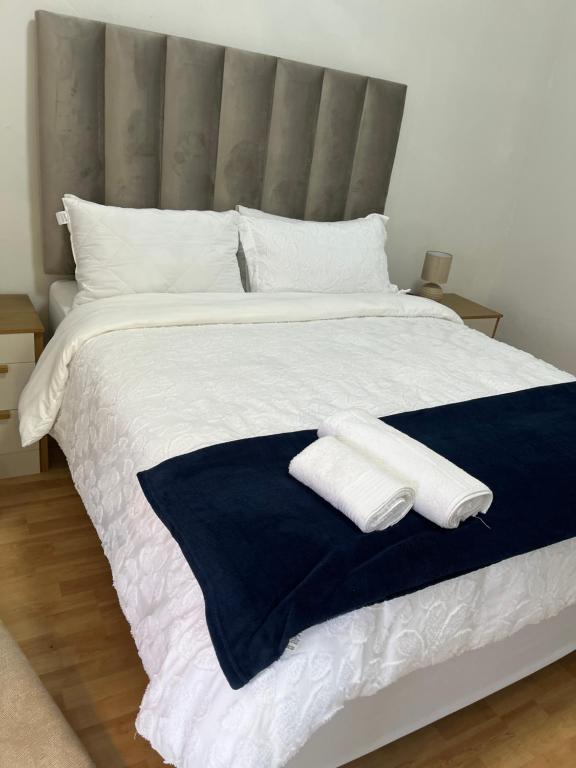 a large bed with two white towels on it at Lungi and Rendzo Guesthouse in Alberton