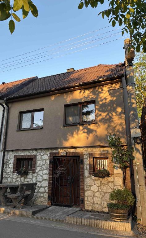 a stone house with a gate in front of it at Sklípek Glosovi in Hovorany