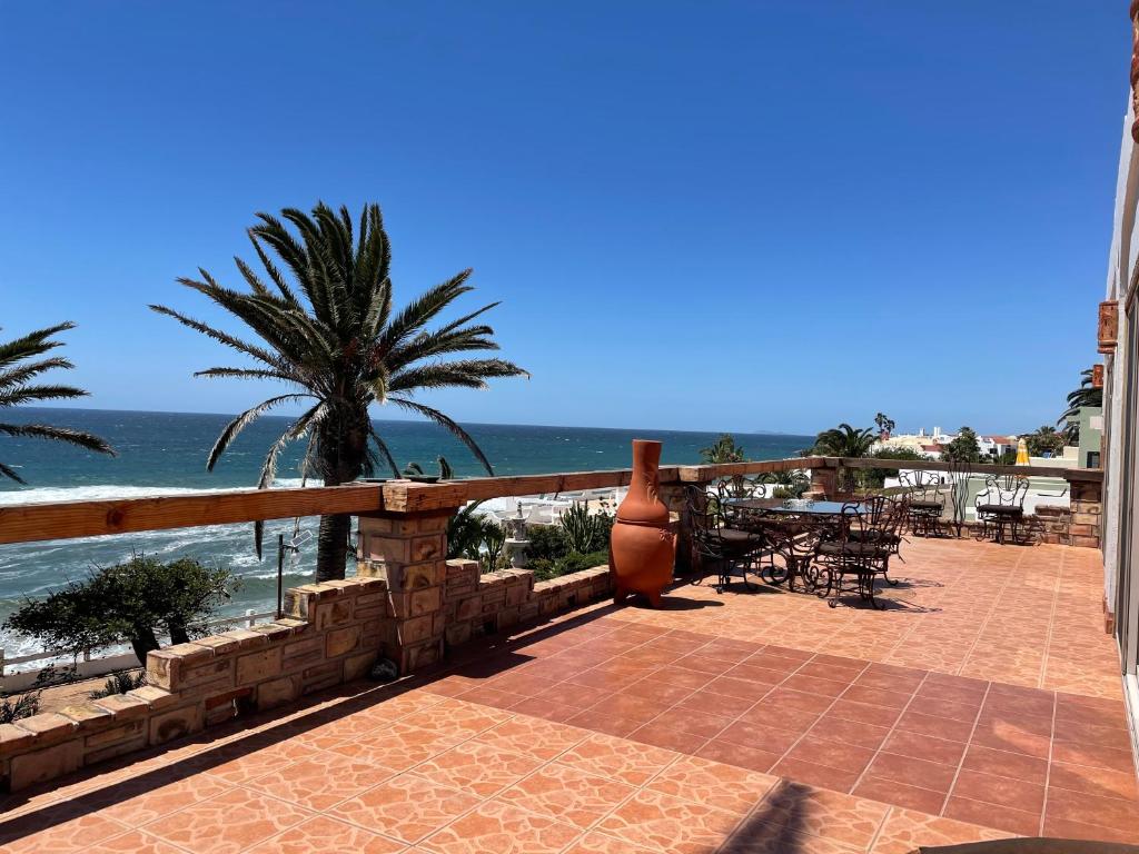 a patio with a table and chairs and the ocean at Ocean Front Baja Vacation in Rosarito
