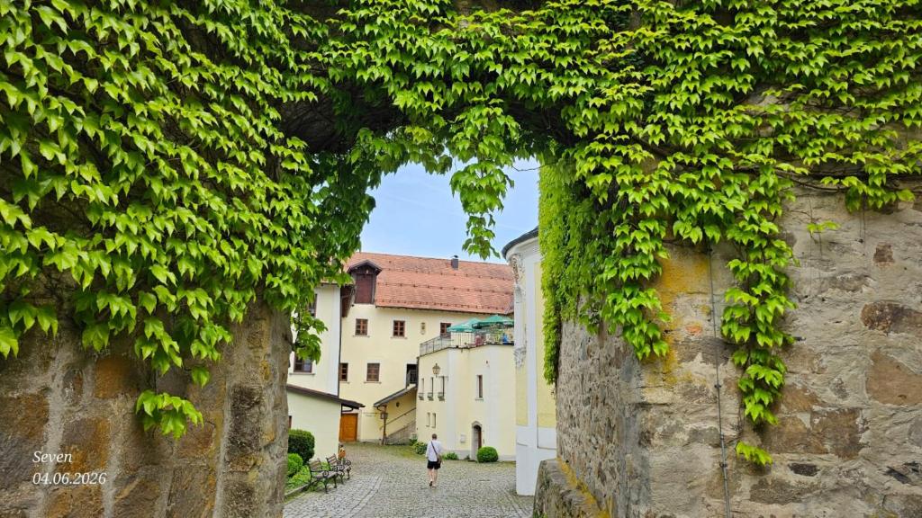 a person walking down a street between two buildings at Zum Schlosswirt in Fürsteneck