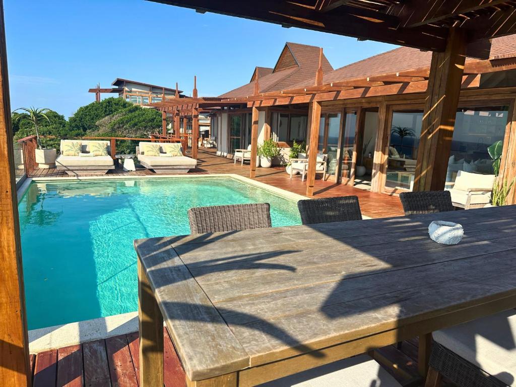 a patio with a table and a swimming pool at Aloha 28 in Ponta Mamoli