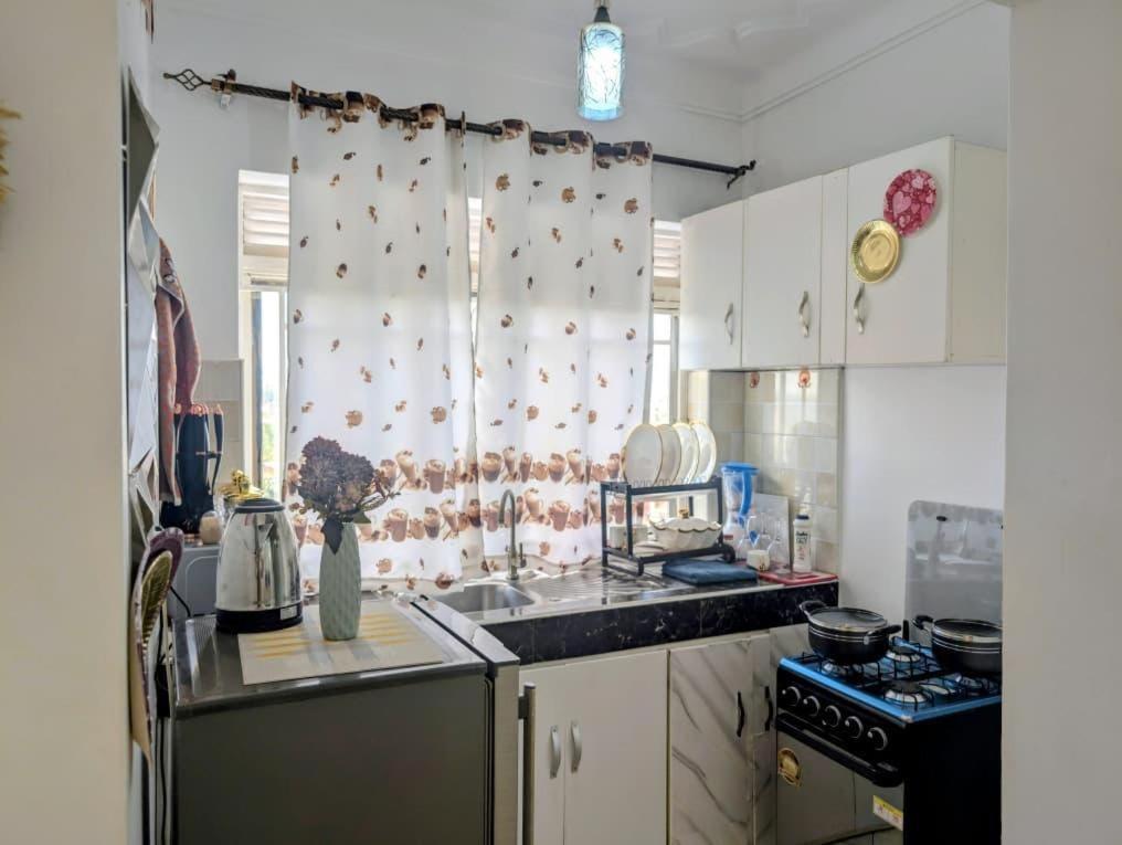 a kitchen with a sink and a stove top oven at LyzHomes in Kampala