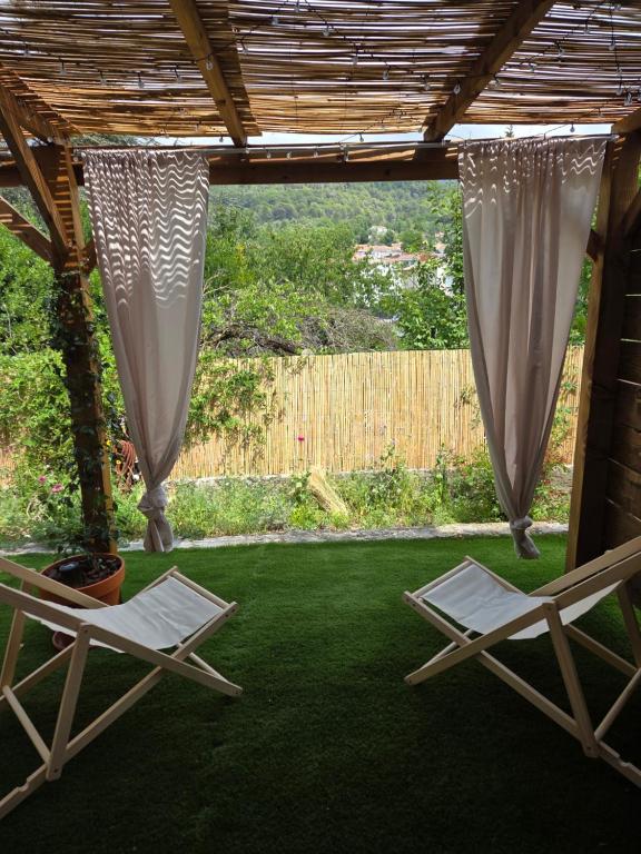 two chairs sitting on the grass under a pergola at Le Sargier in Levens