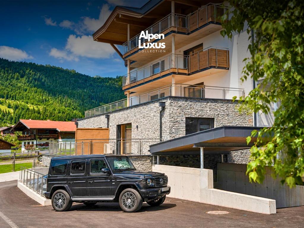 a black jeep parked in front of a building at BASE Achensee - Opening August 2026 in Achenkirch