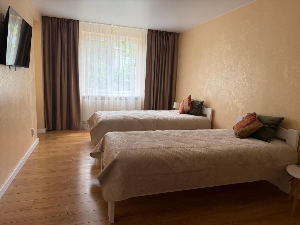a hotel room with two beds and a window at Sunny Apartment in Otaci