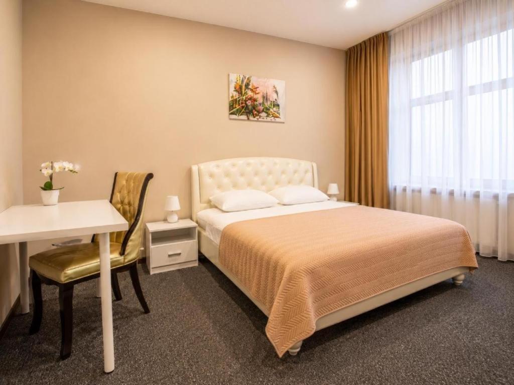 a bedroom with a bed and a table and a desk at Nika Apart hotel in Riga