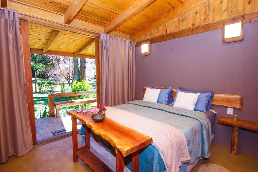 a bedroom with a bed with a wooden ceiling at Espaço Gata Mourisca in Camanducaia