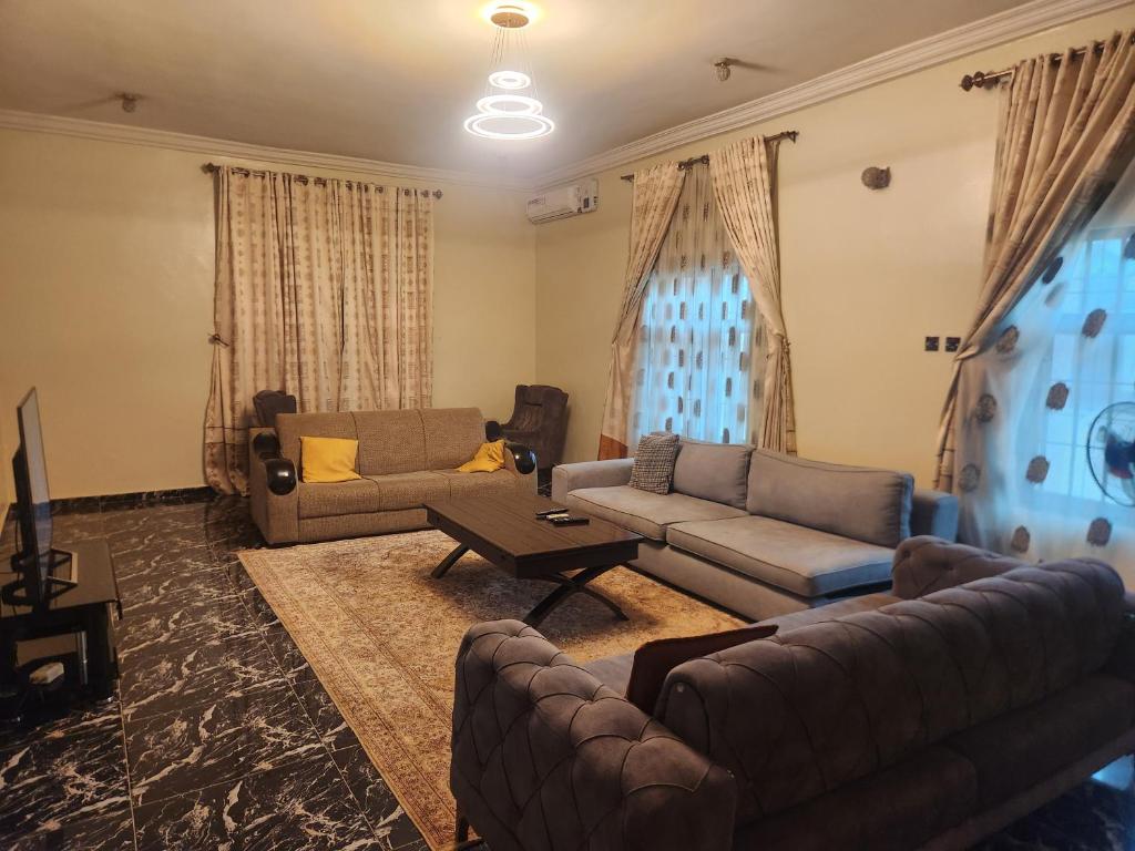 a living room with two couches and a tv at Afiraiserviceapartment in Kaduna