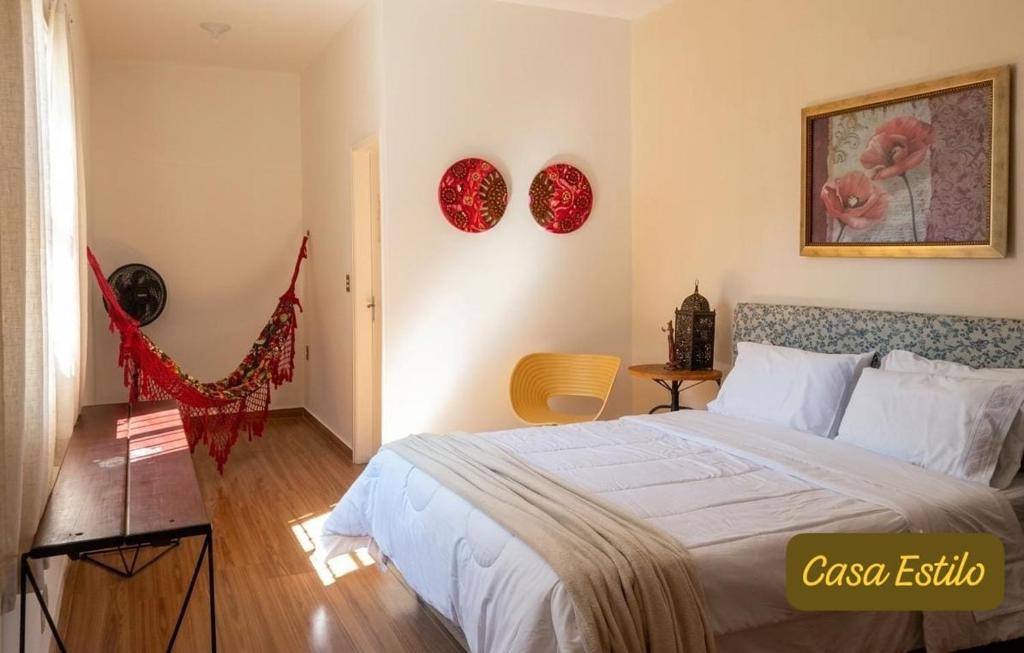 a bedroom with a bed and two pictures on the wall at Casa Estilo - São Lourenço in São Lourenço