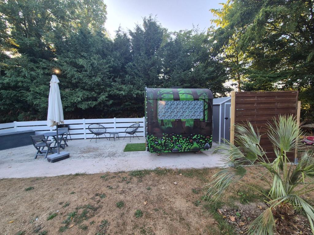 a patio with a table and chairs and an umbrella at Carabois in Esson
