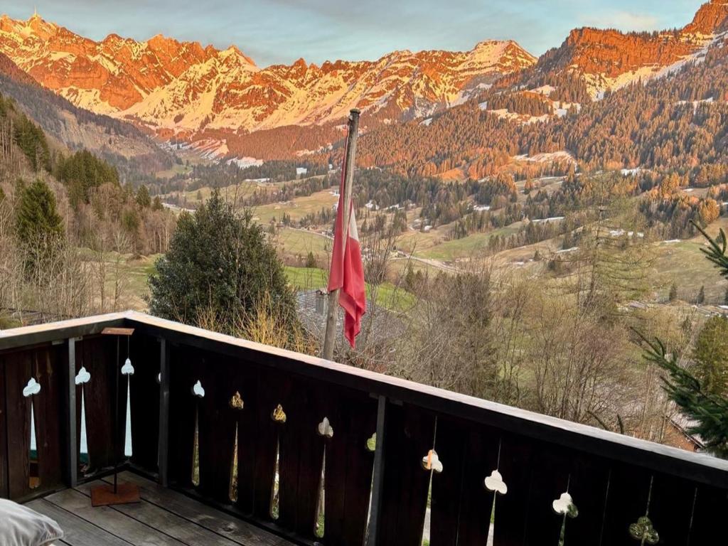 a flag on a balcony with mountains in the background at Alp Chnorz Penthouse in Nesslau