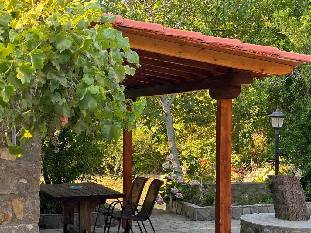 a wooden pergola with two chairs and a table at Kyveli Homes in Therma