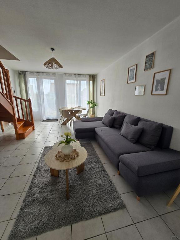 a living room with a couch and a table at Charmante maison Marnaise in Vauclerc