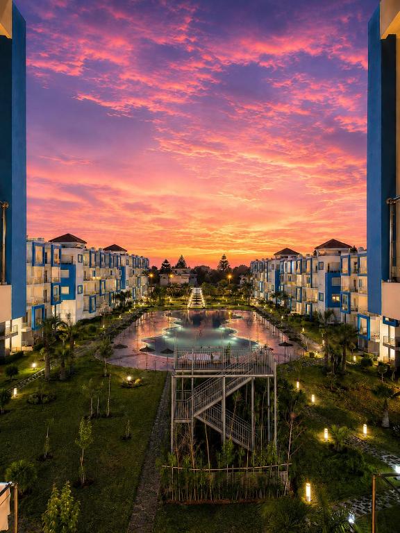a view of a city at sunset at Appartement standing terrasse privative et piscine - Kariat Cabo in Cabo Negro