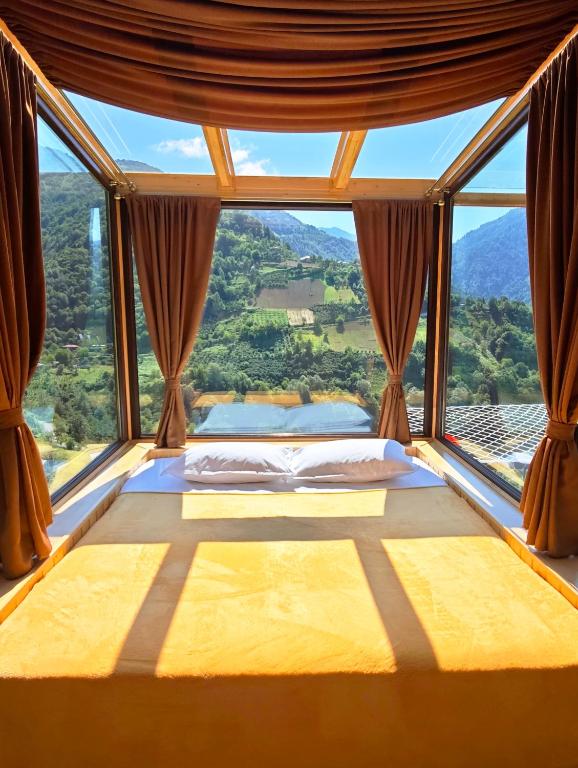 a bed in a room with a large window at Glass House Merisi 2 in Merisi