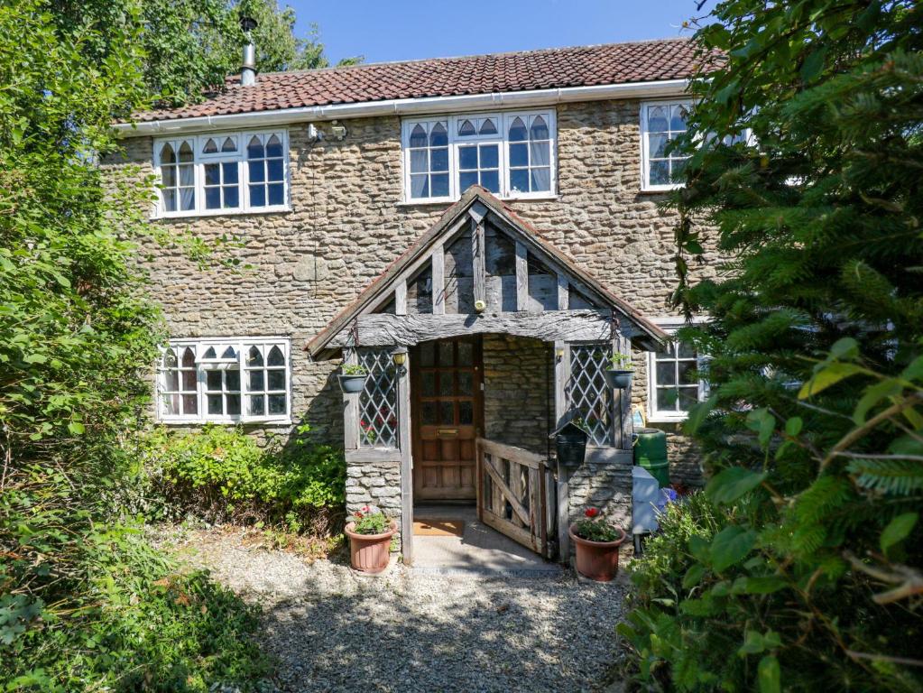 a brick house with a wooden door and a gate at Ivy Cottage in Bath