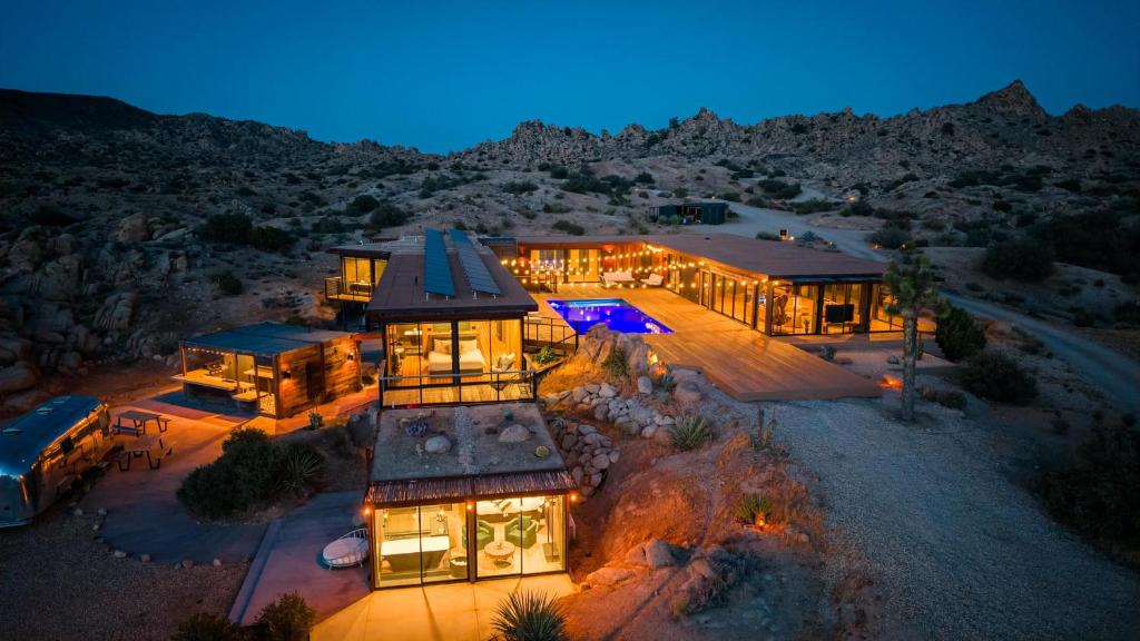 an aerial view of a house in the desert at night at Iconic 7,000sf Glass Villa with 2 Pools on 350 Acres in Pioneertown