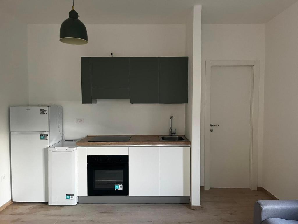 a kitchen with white cabinets and a refrigerator at Bigò Apartments in Termoli